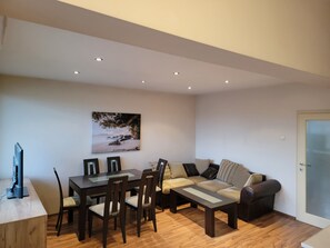 A modern living room with a dining table, chairs, a sofa, and a coffee table.