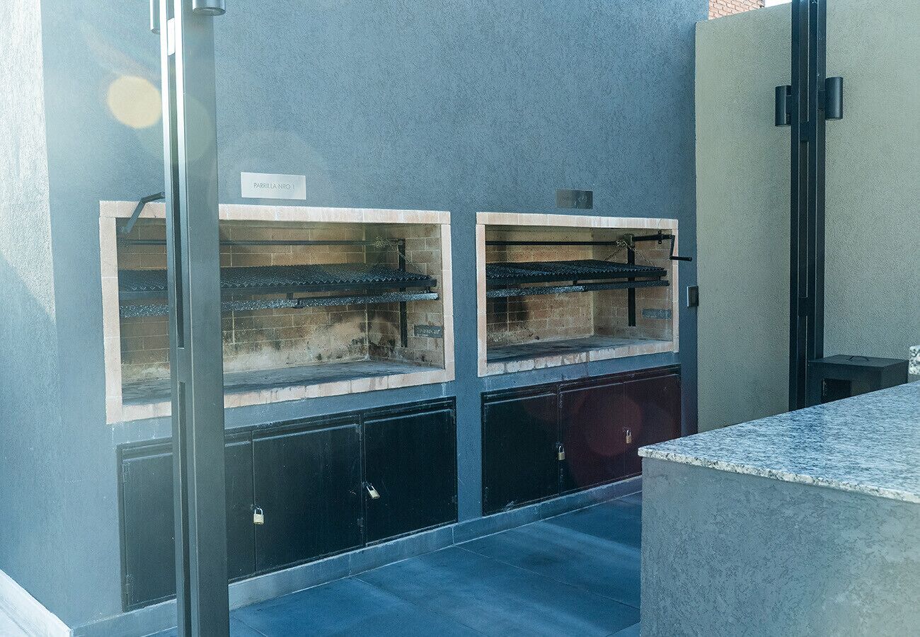 A room with a large window, a metal door, and a small table.