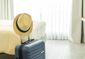 A room with a bed, a suitcase, and a straw hat. - San Telmo: Modern, with Premium Amenities, Strategic Connection (Buenos Aires)