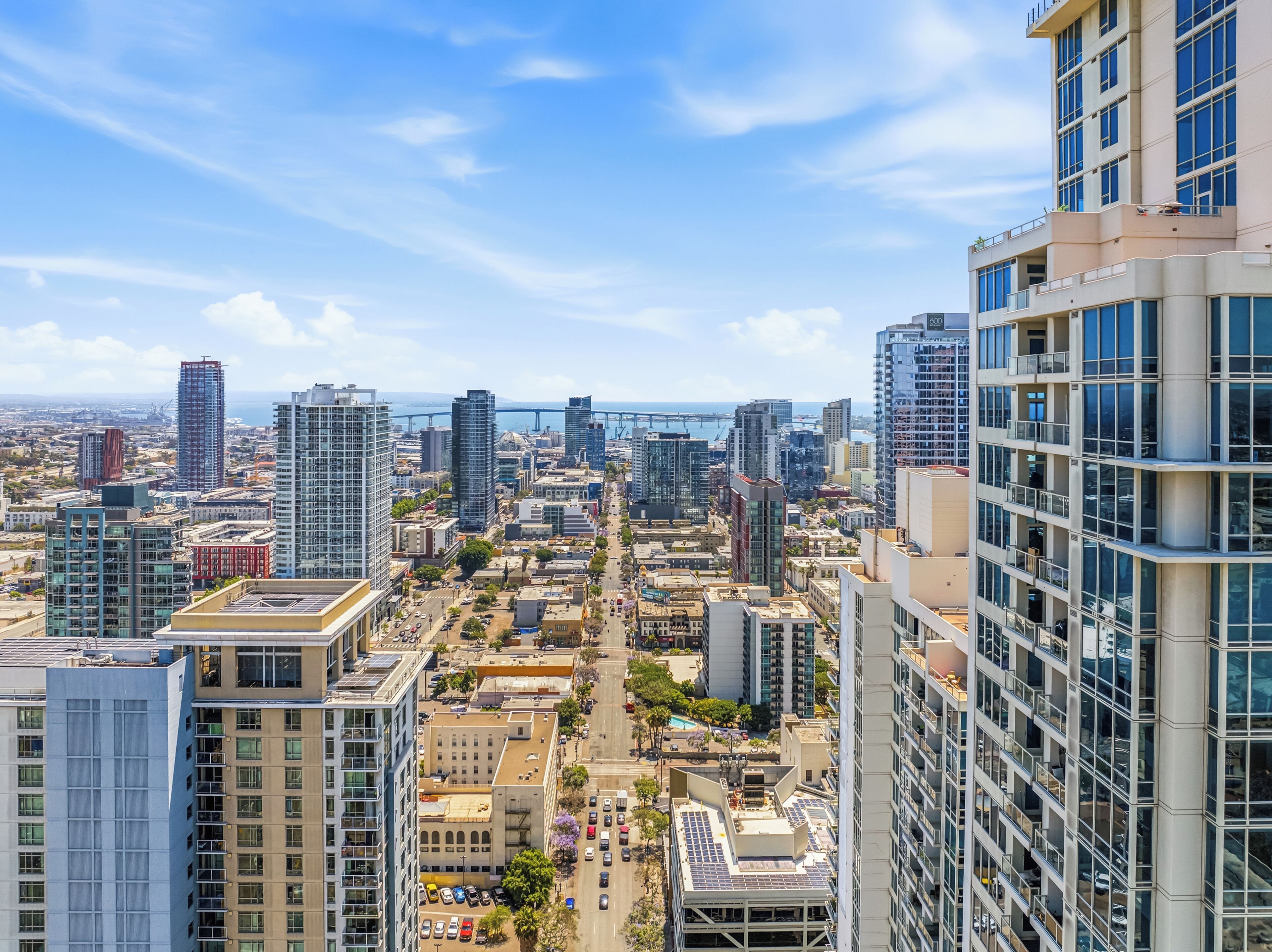 A cityscape with high-rise buildings, a bridge, and a clear sky.