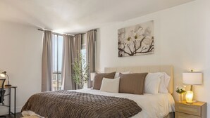 Ein Schlafzimmer mit Bett, Nachttisch, Lampe und einem Bild an der Wand.
