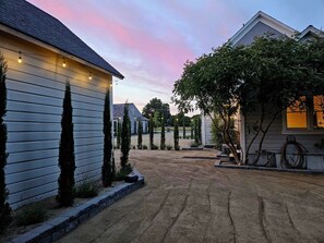 A residential driveway with a gravel surface, bordered by a low curb, and houses on either side. - Villa Brut- Built in 1902 to hold ice. Now it holds guests. (Dundee)