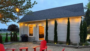 A house with a covered patio, outdoor seating, and a grill.