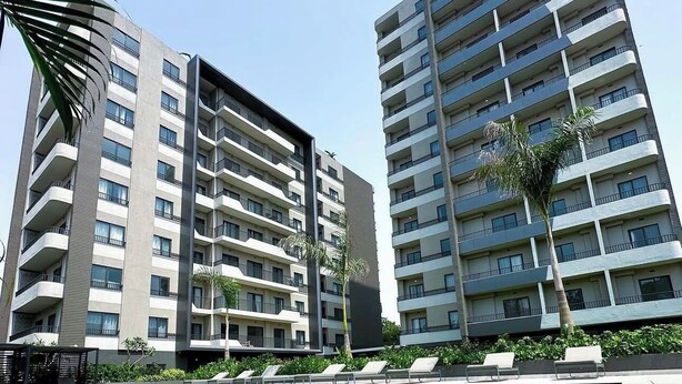 A modern hotel with a swimming pool, multiple balconies, and a clear blue sky. - Delali Residence Luxury 1BR Near Airport, Pool, Gym & private Terrace (Accra)
