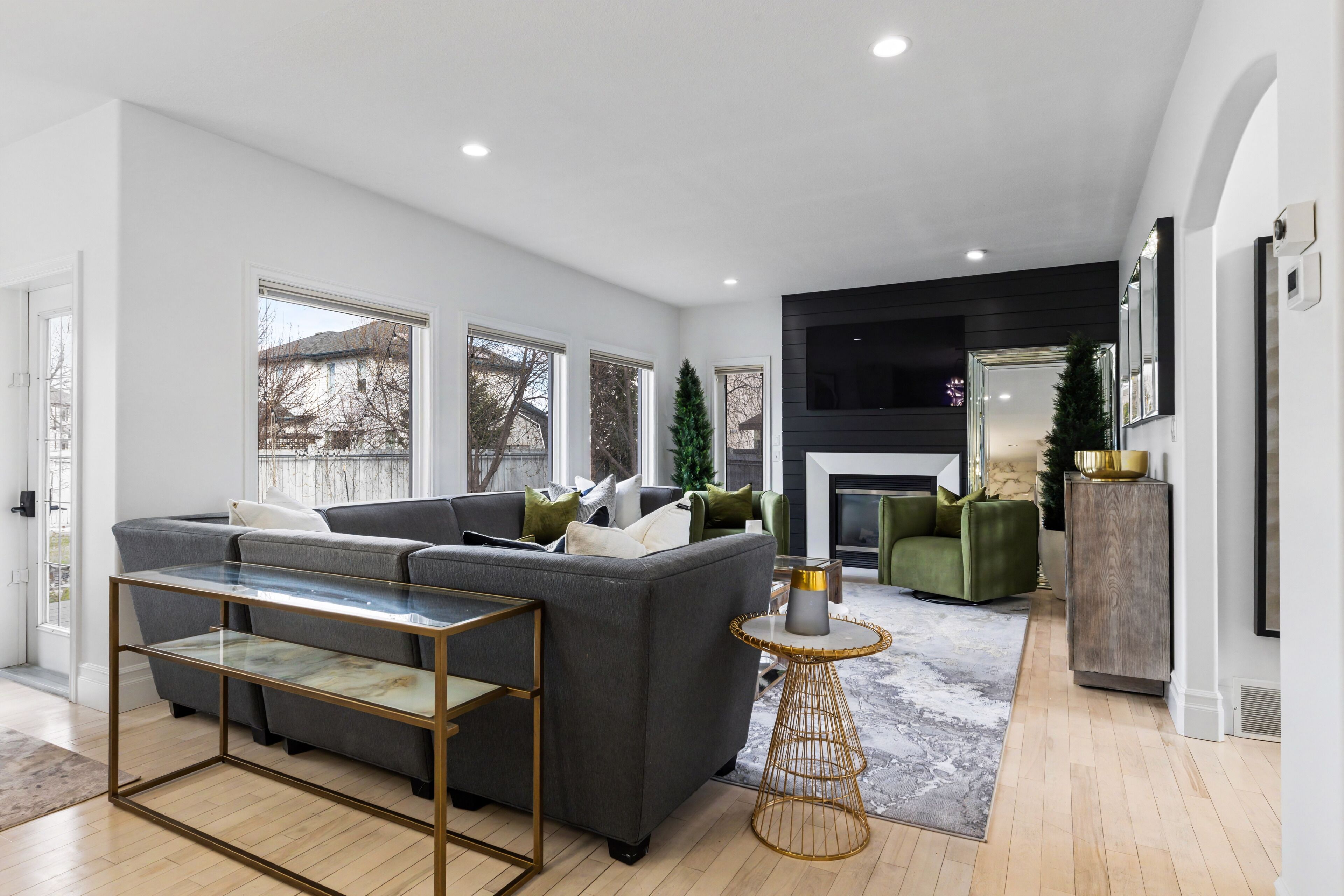 Een moderne woonkamer met een modulaire bank, een glazen salontafel en een open haard.