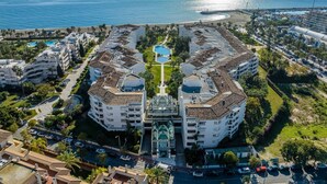 Et kysthotel med central pool, flere balkoner og havudsigt.
