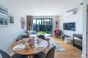 Un salon moderne comprenant un coin repas, un téléviseur et une cheminée.