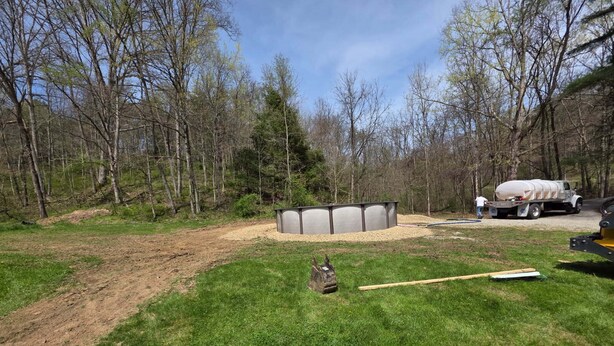 A backyard with a shed, a gravel area, and a truck.