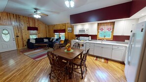 A cozy cabin-style interior with a dining area, kitchen, and living room.