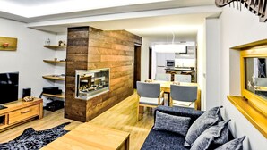 A modern living room with a fireplace, wooden furniture, and a dining area. - Luxury Wellness by Interhome (Rokytnice nad Jizerou)