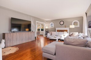 Ein Wohnzimmer mit Fernseher, Sofa und Kamin.