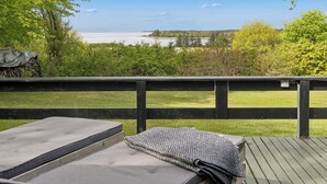 Een terras met twee matrassen en uitzicht op een waterlichaam.