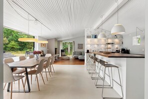 Een modern interieur met een eethoek, keuken en bar.