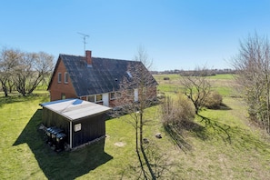 A house with a sloped roof, a chimney, and a small attached shed.