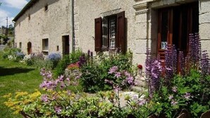A stone building with a garden in front. - Grand Gîte La Panouse en Margeride (LA PANOUSE)