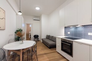 A modern kitchen with white cabinets, a built-in oven, and a blue backsplash. - Newly renovated 1BR Apartment - Washington/Tolstoi 15 min away from Duomo (Milano)