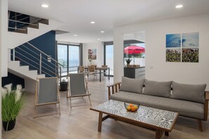 Un salon moderne avec un canapé, une table basse et un escalier.
