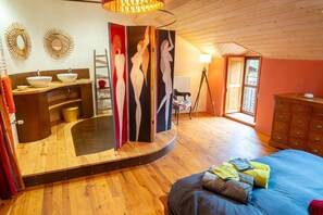A bedroom with a bed, a dresser, a vanity with a mirror, and a window. - Chez MamieThé - ISPAGNAC (ISPAGNAC)