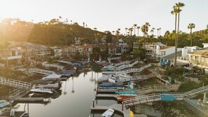 A marina with boats docked, a small dock with a chair, and a building with a balcony.