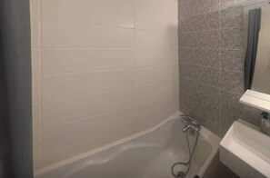 Ein Badezimmer mit Badewanne, Dusche und Waschbecken.