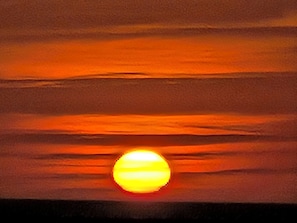 Ein Sonnenuntergang mit sichtbarer Sonne.