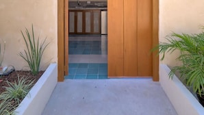 Un ingresso stretto a un edificio con una porta in legno e una piccola finestra.