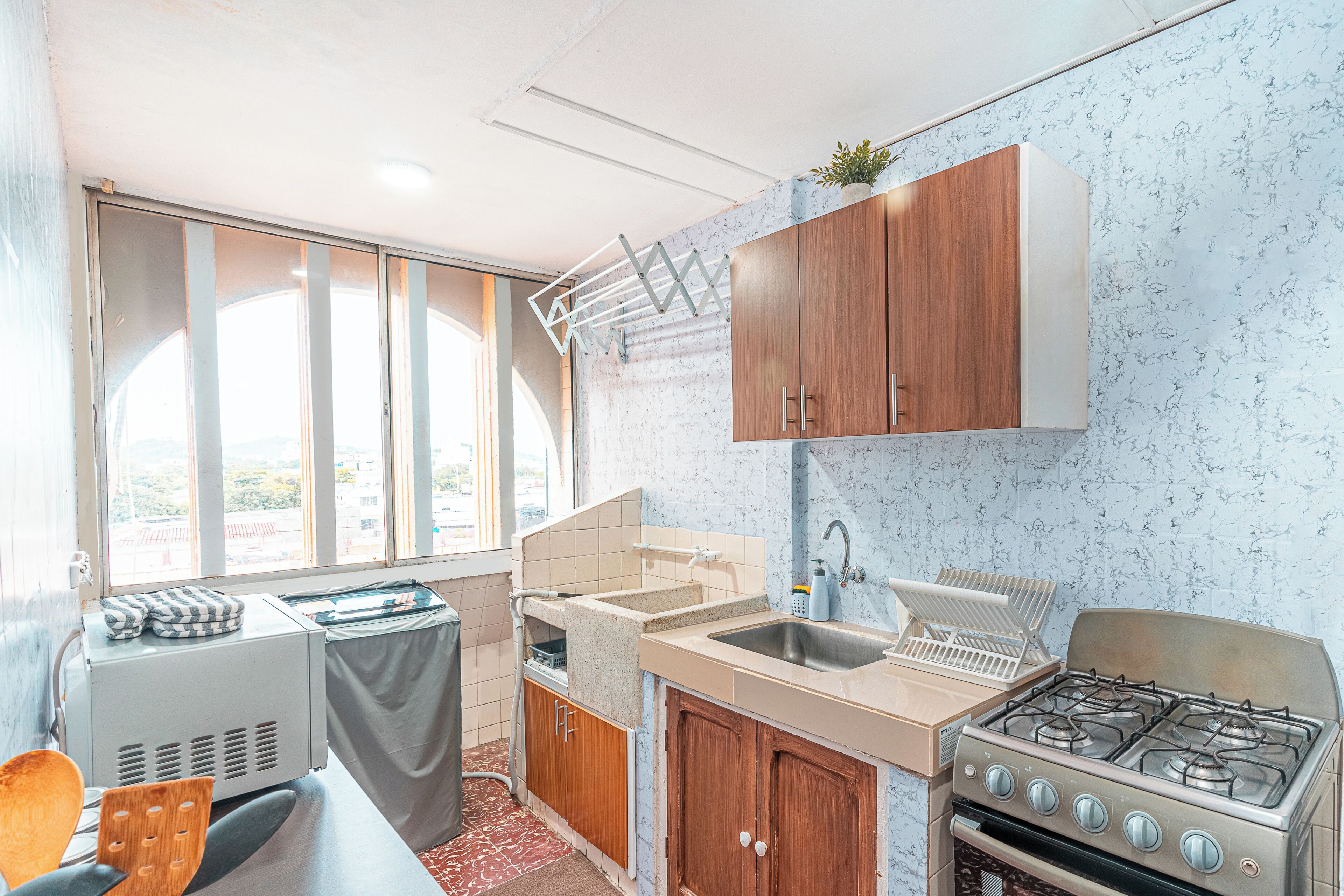 Una cucina con piano cottura a gas, lavello e mobili in legno.