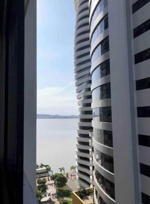 A high-rise building with a curved facade, large windows, and a view of a body of water. - Cozy apartment in the heart of Guayaquil (Guayaquil)