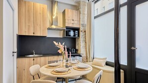 Een moderne keuken met houten kastjes, een ronde eettafel en een inbouwmagnetron.