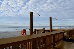 A wooden deck with a railing overlooking a beach. - Beachfront 3BR Retreat w/ Balcony & Pool (Murrells Inlet)