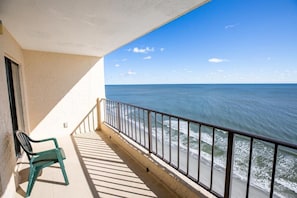 A balcony with a view of the ocean, a chair, and a railing. - Beachfront 3BR Retreat w/ Balcony & Pool (Murrells Inlet)