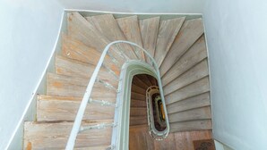 Un escalier en colimaçon avec des marches en bois et une rampe métallique.