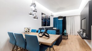 Ein moderner Essbereich mit Holztisch, blauen Stühlen und einer besonderen Leuchte.