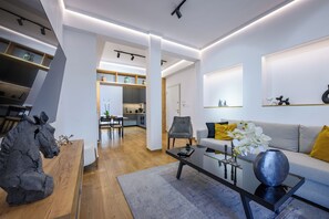 A modern living room with a sofa, coffee table, and decorative items. - Acropolis Golden View Penthouse | 17 Dimitrakopoulou str 11742 Athens (Athens)