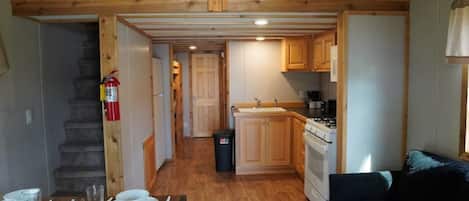 A compact kitchen with wooden cabinets, a stove, and a sink.