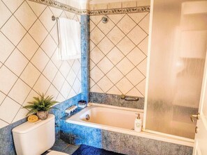 Ein Badezimmer mit Badewanne, Toilette und Dusche.