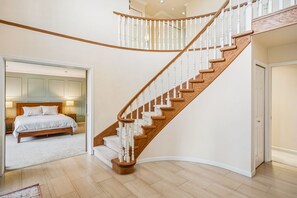 Ein Schlafzimmer mit einem großen Bett, einer Wendeltreppe und Blick auf den Flur.