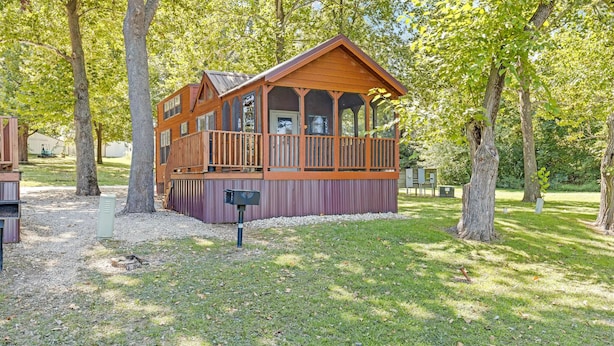 A wooden cabin with a balcony, surrounded by trees. - Family Escape | 2 Units | Lakefront Cabin, Seasonal Pool & Water Activities (Pike County)