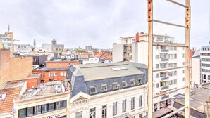 Stadsgezicht met diverse gebouwen, waaronder een opvallend wit gebouw met balkon en een gebouw van rode baksteen op de voorgrond.