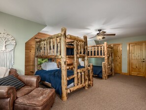 A cabin-style bedroom with a bunk bed, a ceiling fan, and a wooden door. - Private, Mountain Views, Hot Tub, WiFi, Kid & Dog Friendly, Hike to the creek! (Maggie Valley)