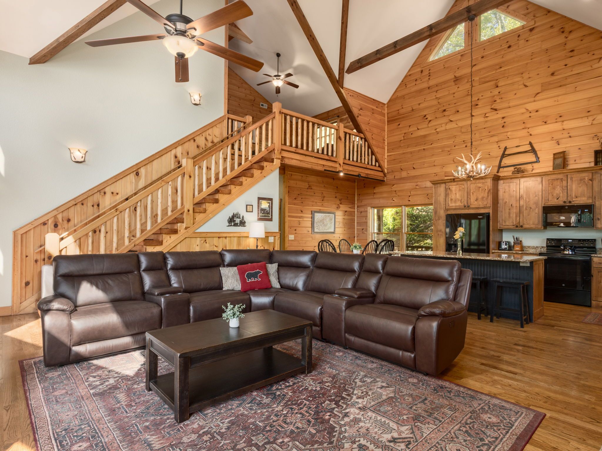 A spacious living area with a sectional sofa, a coffee table, and a patterned rug.