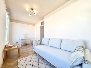 Ein modernes Wohnzimmer mit einer Couch, einem kleinen Tisch und einem Sessel.