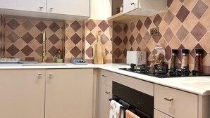 A kitchen with a gas stove, a toaster, and various kitchen utensils. - Elegant Newly Renovated Apartment - Notting Hill (London)