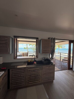 Eine moderne Küche mit Meerblick, Holzschränken und einer Spüle.