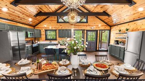 A spacious kitchen with wooden beams, a large island, and a dining area set for a meal. - 2 Bowling Lanes | 8BR Smoky Mtn Lodge | Hot Tub + 85° Pool + Arcade | Sleeps 22 (Sevierville)