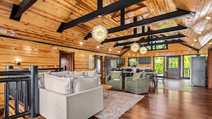 A spacious living area with a sofa, chairs, a dining table, and a kitchen in the background. - 2 Bowling Lanes | 8BR Smoky Mtn Lodge | Hot Tub + 85° Pool + Arcade | Sleeps 22 (Sevierville)