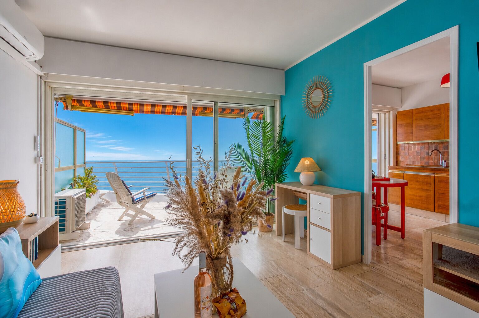 Un soggiorno moderno con vista sul mare, una zona pranzo e una cucina.