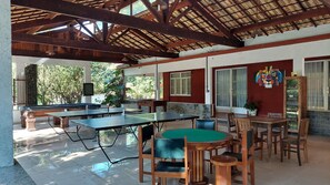 An indoor recreational area with ping pong tables, chairs, and a billiards table. - A paradise among mountains, 1 hour from Rio, for up to 60 people. (Guapimirim)