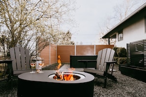 An outdoor seating area with a fire pit, two Adirondack chairs, and a table. - Swanky Speakeasy Stay-Hot Tub + Firepit-Minutes to Downtown (Moscow)
