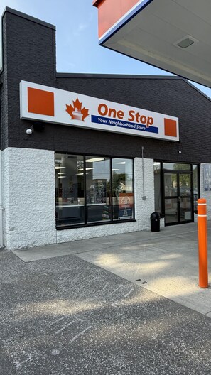 A storefront with a sign reading 'One Stop Your Neighborhood Store' and a visible entrance.